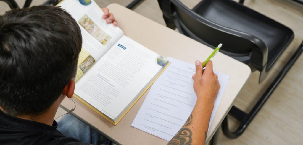 Persona llegint un llibre i prenent notes per a millorar la comprensió lectora